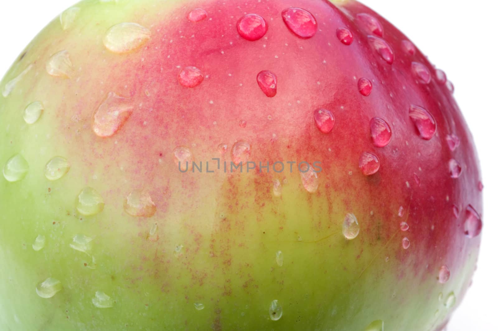 Red ripe apple with liquid drops close up.