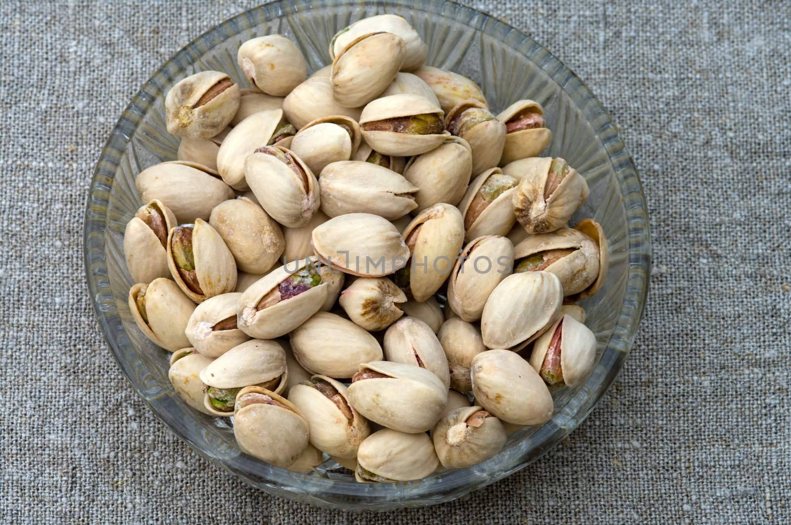 Pistachios in a glass plate close up.