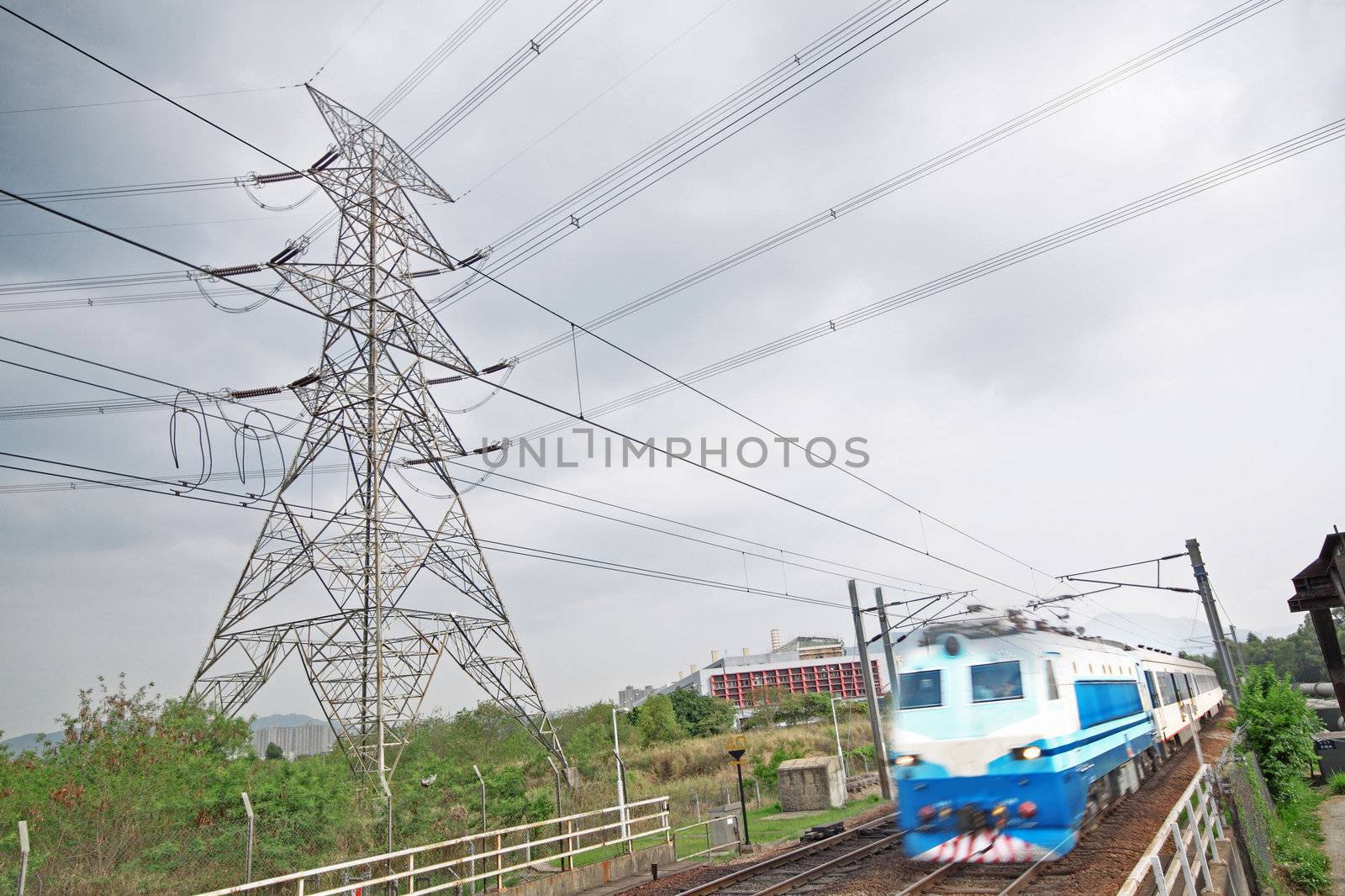 passenger trains in motion and power tower on background 