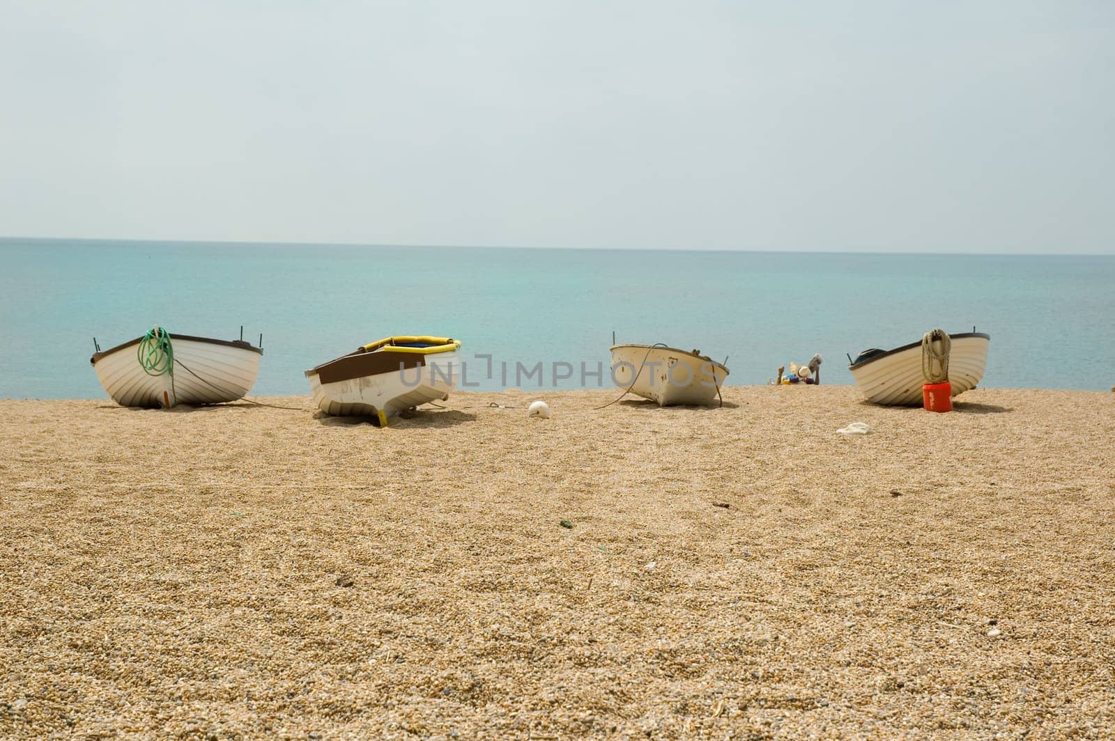 beach scene with a group of small boats on the gravel