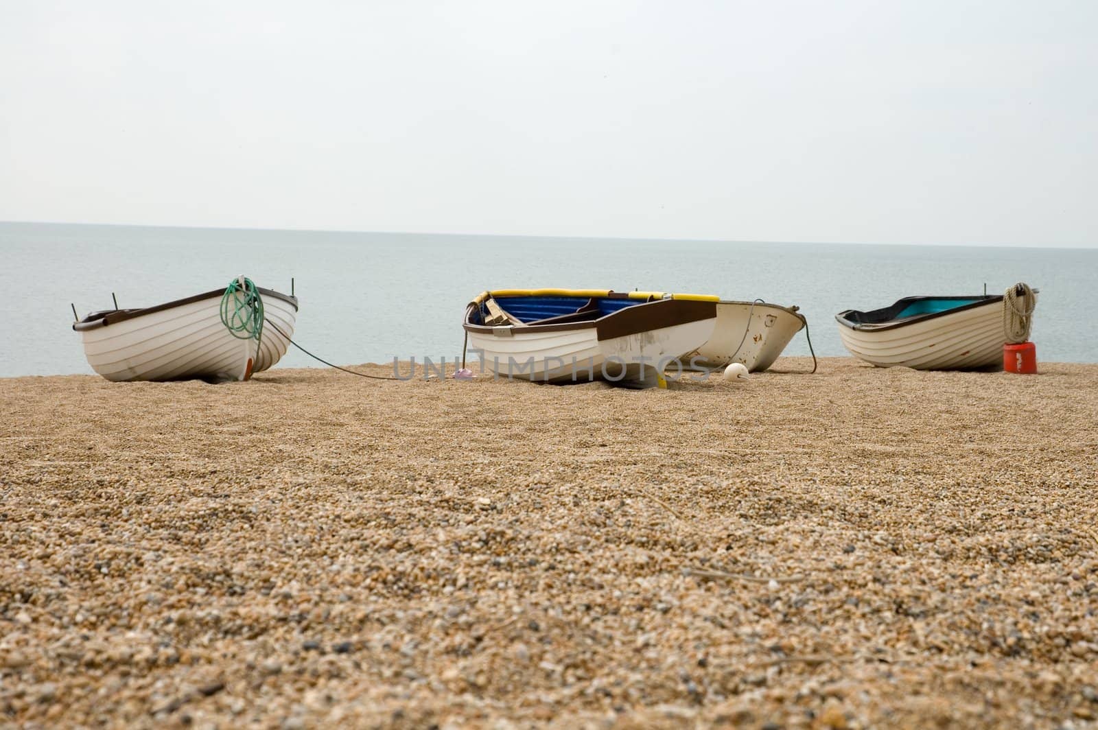 beach scene with a group of small boats on the gravel