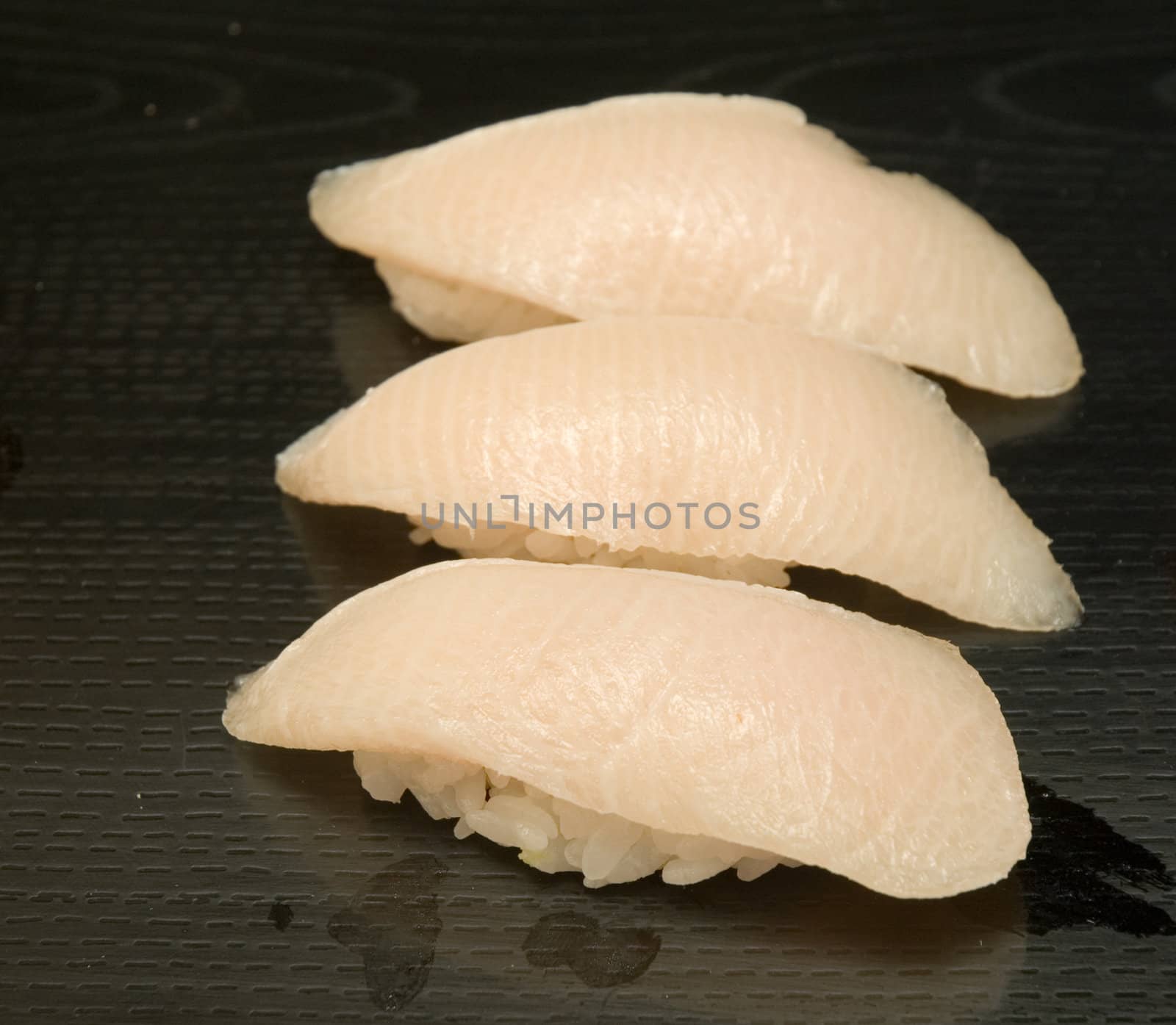 A series of sushi plates at an outdoor venue with a shallow depth of field