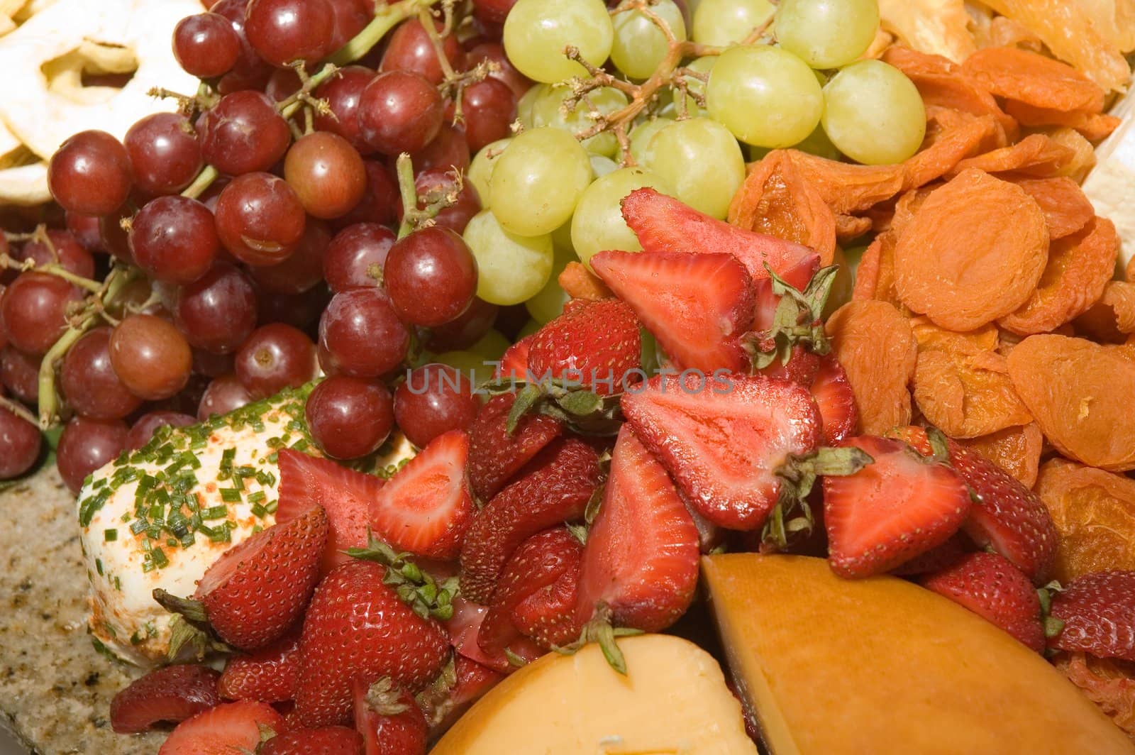 Assortment of fresh and dried fruits with a variety of cheeses