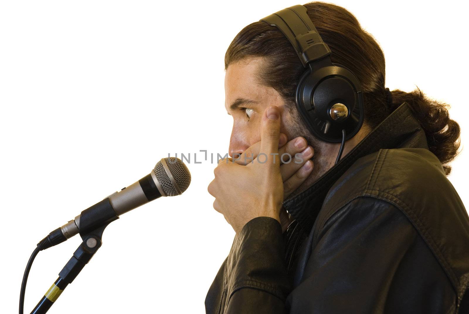 Profile of a young man in a leather jacket, covering his mouth with both hands in front of a microphone - surprised face.
