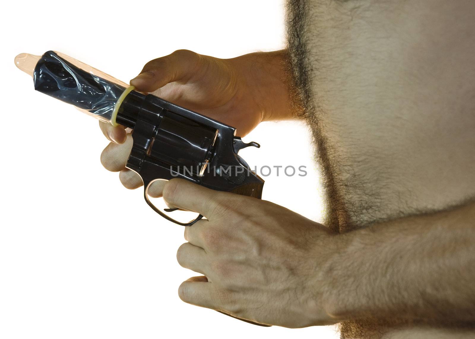 Cropped shot of a male hand holding a .38 caliber with a condom on it and hairy chest from the side. White background.