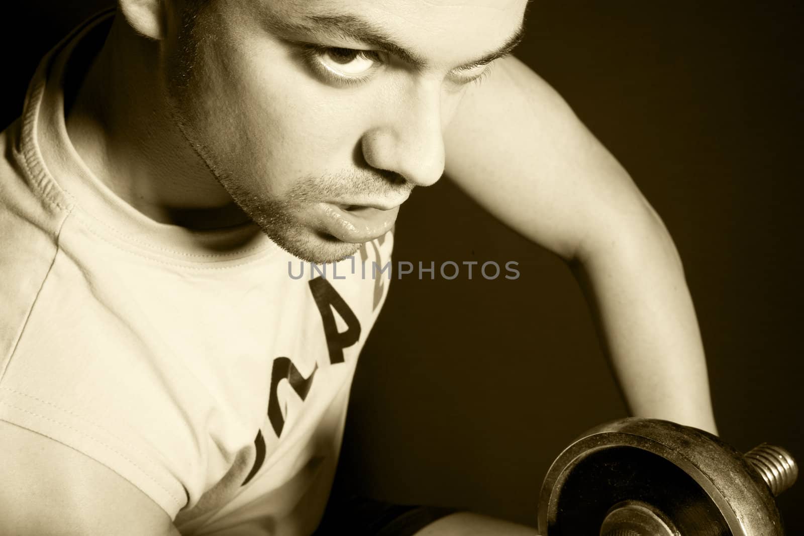 Handsome young man doing weight lifting exercises