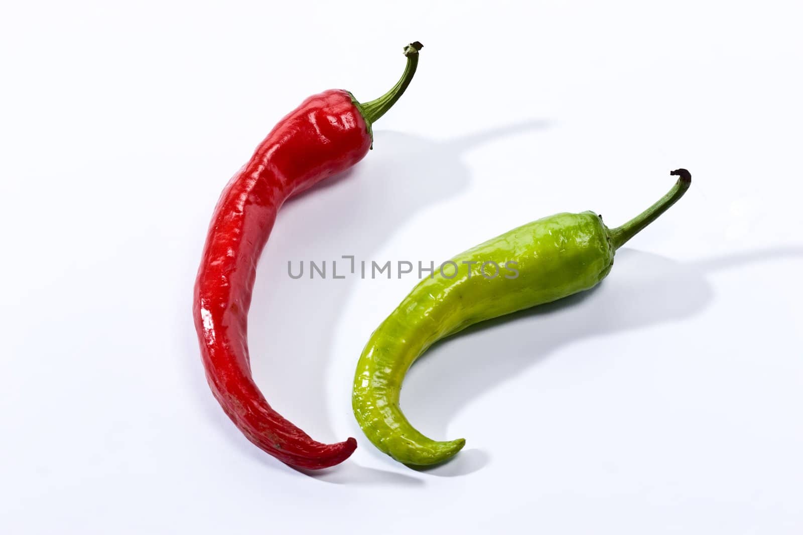 Green and red pepper on the white background