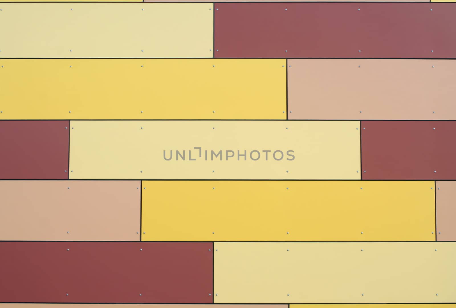 Facade panels in warm yellow and pink tones. Diagonal pattern. Modern office building.