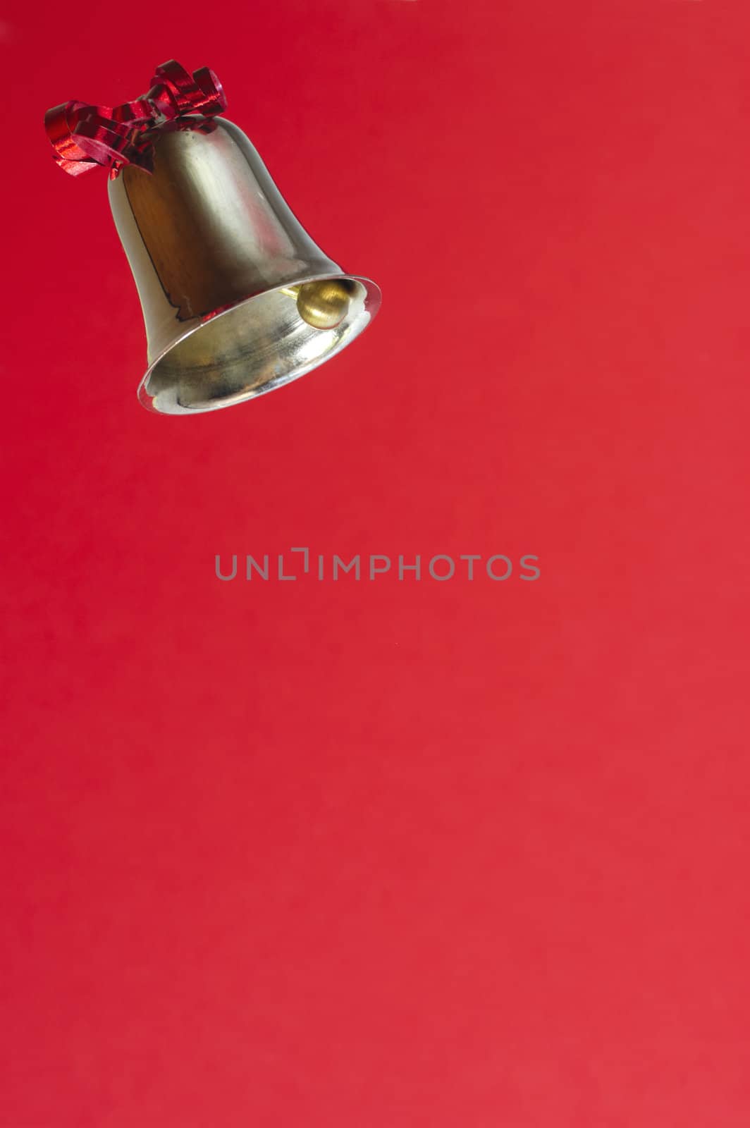 A ringing bell, decorated with a red ribbon. on bright re background, Space for text.