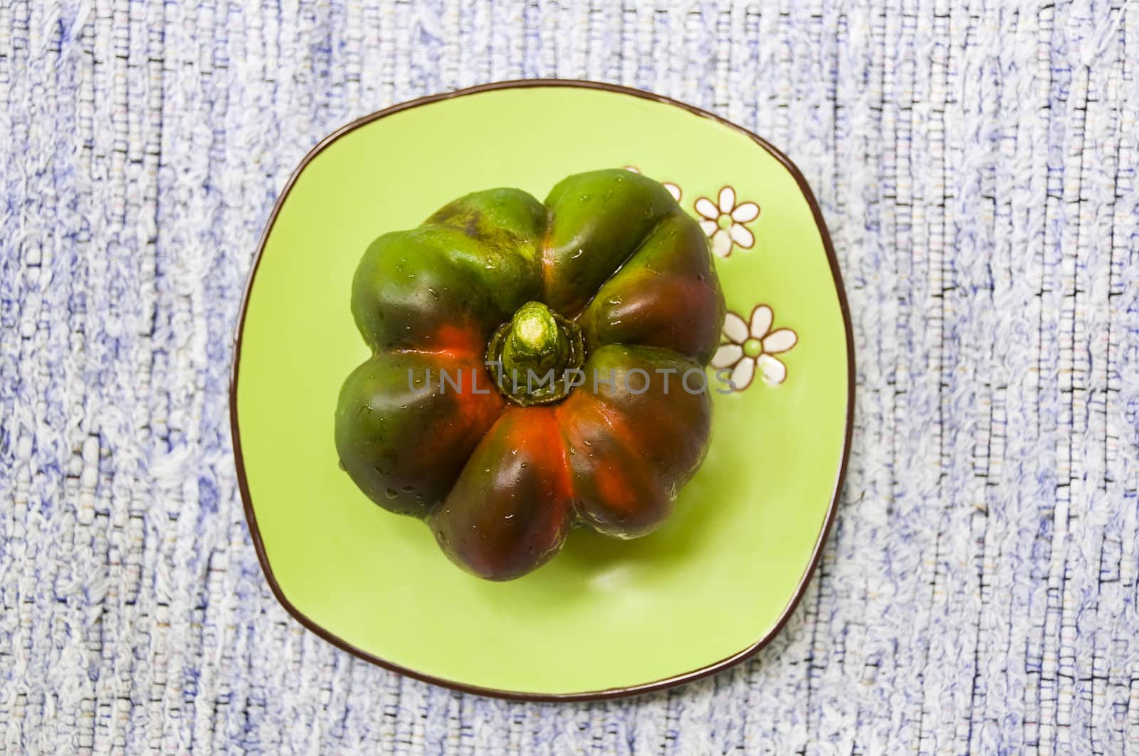 Big bell pepper on green saucer