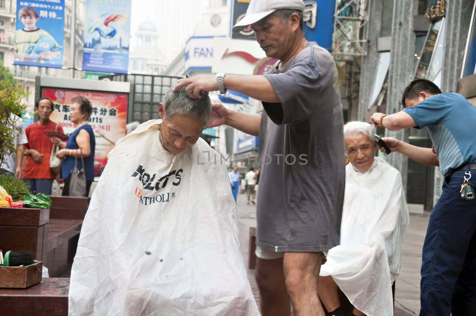 Chinese elders having their hair cut along Nanjing Road, Shanghai