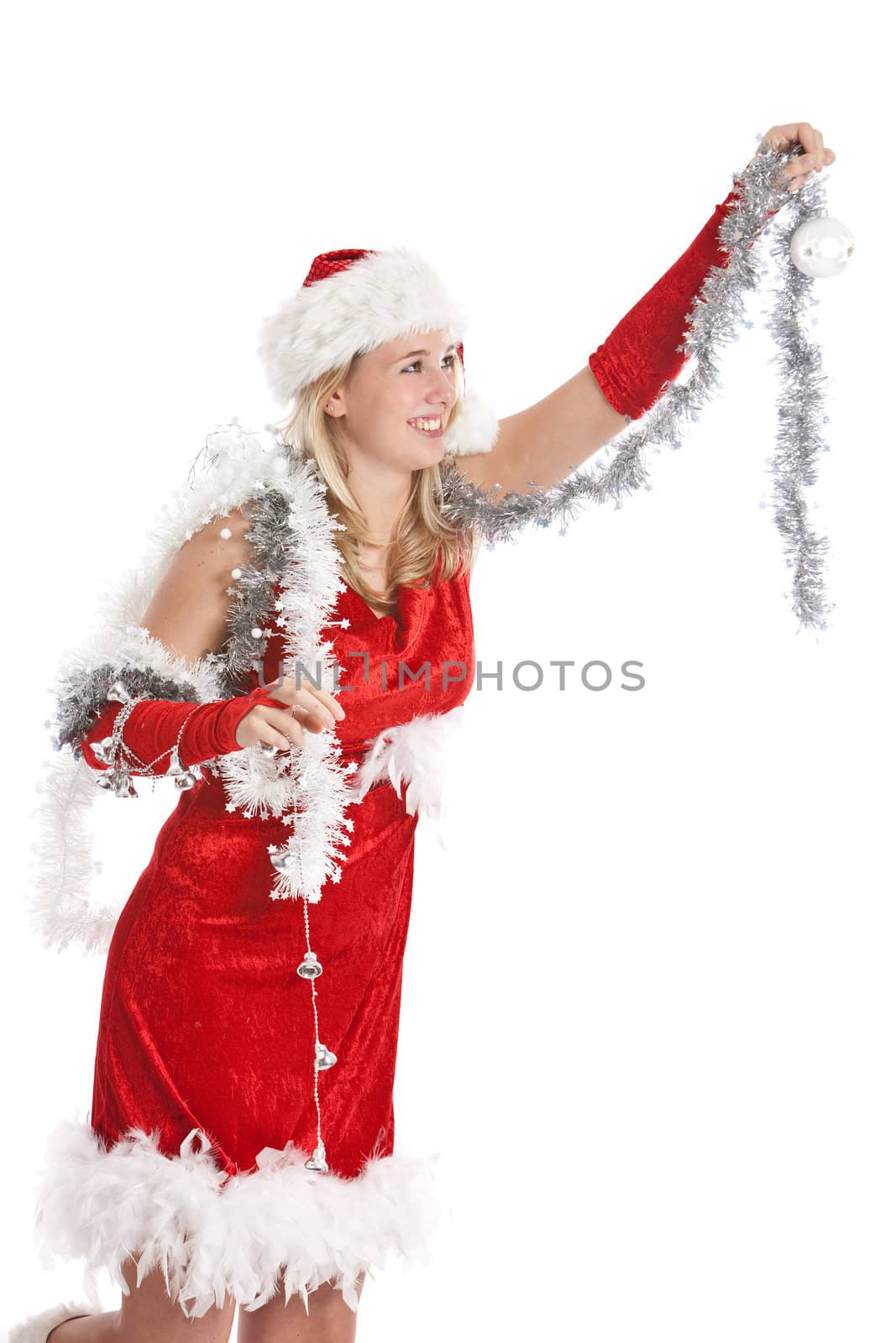 Pretty young girl in santa dress hanging up the baubles