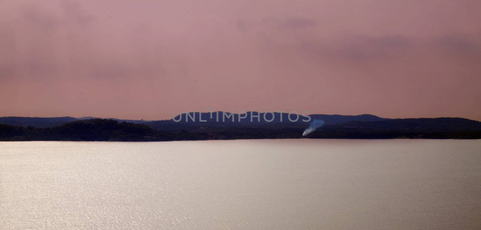 Calm landscape of a lake with sun reflection