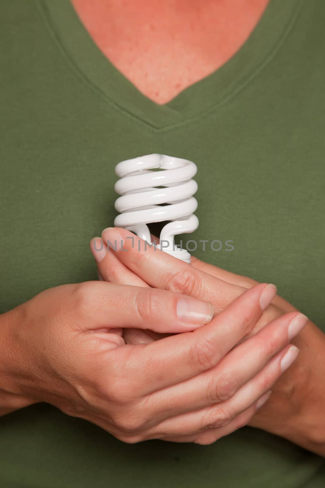 Female Hands Holding Energy Saving Light Bulb by Feverpitched