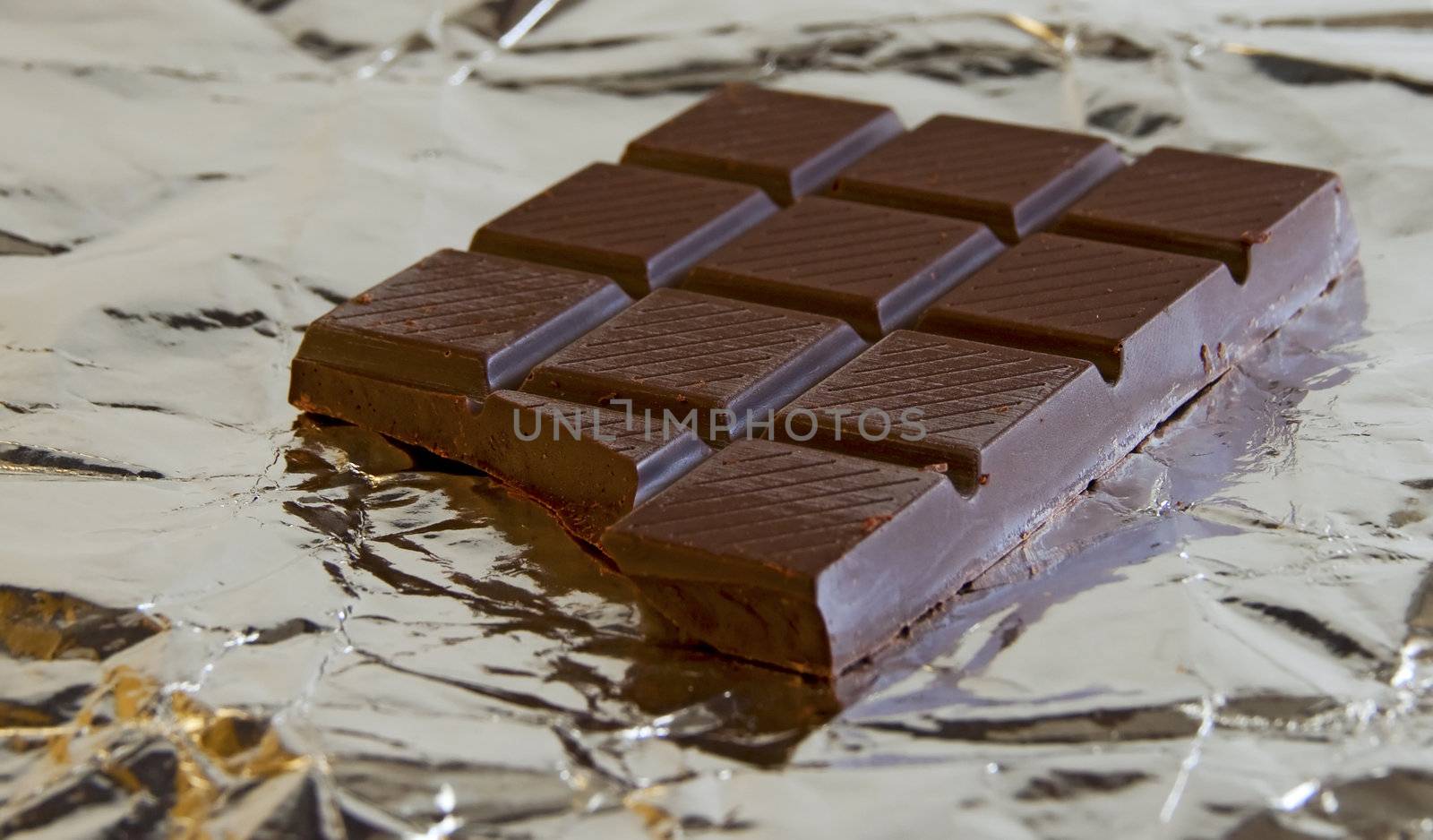 Tablet of dark chocolate over a silver paper