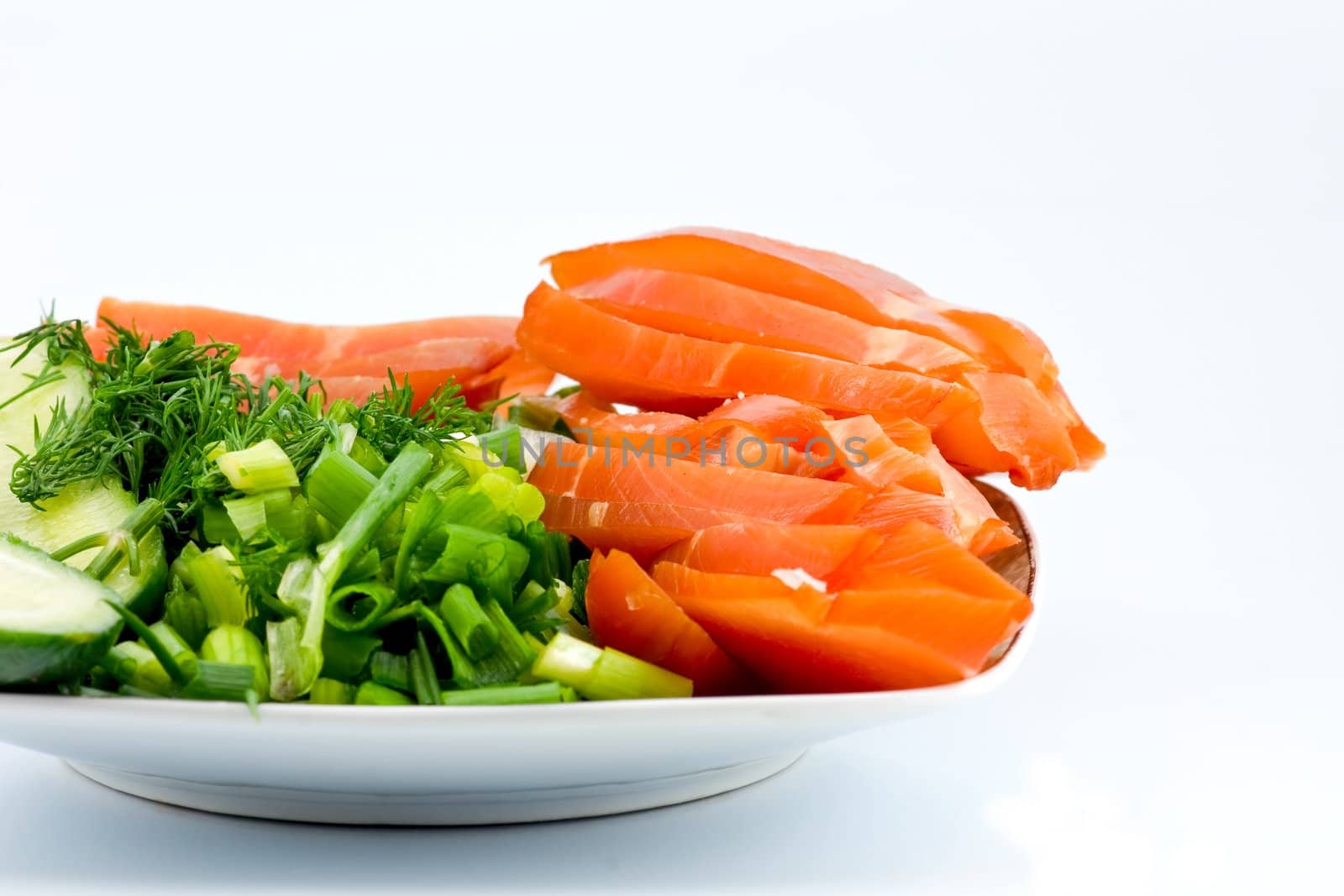 Sliced smoked chicken and vegetables on square porcelain plate
