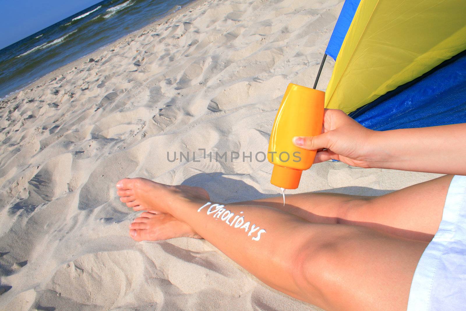Woman with creamy sign I love holidays on her legs
