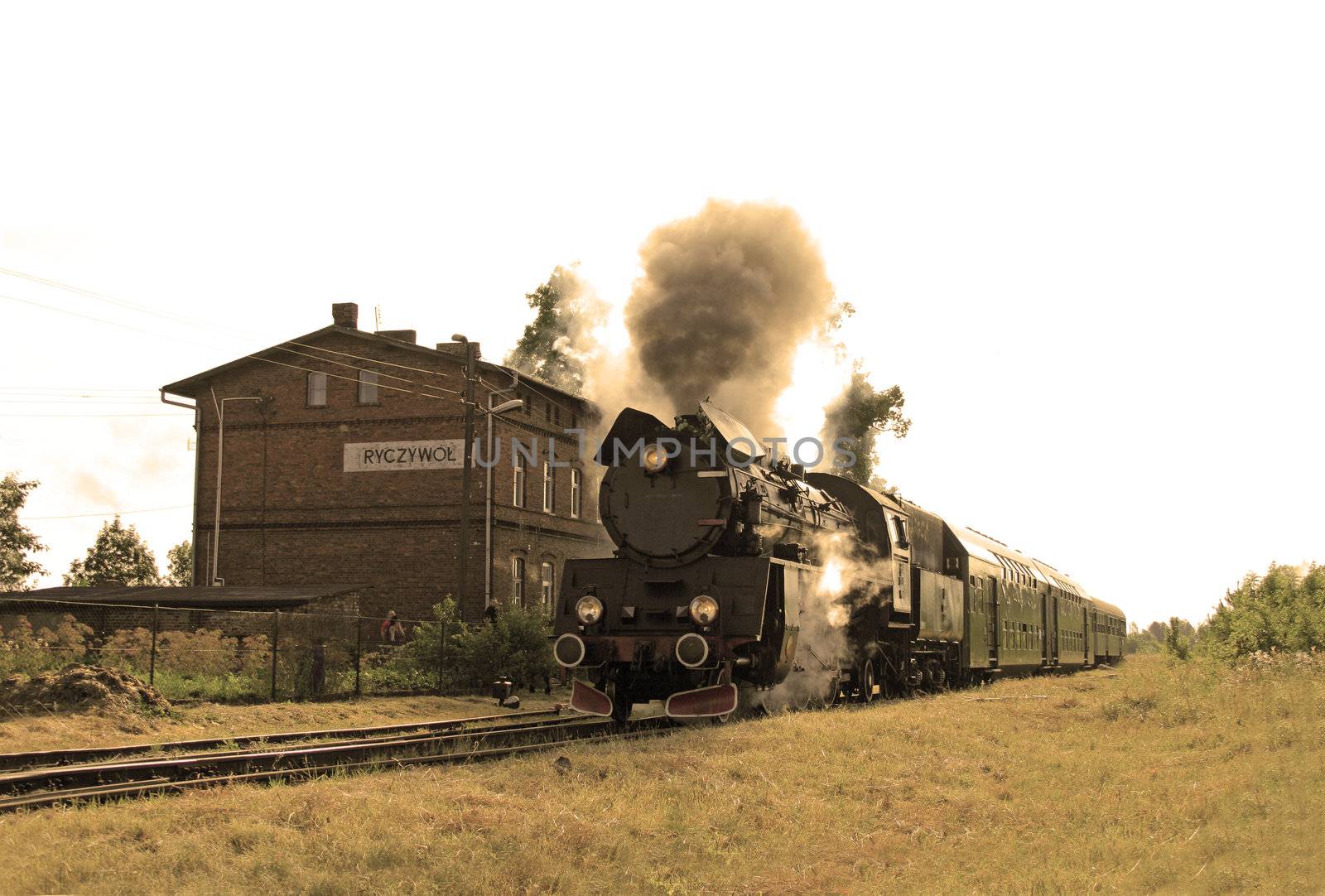 Old retro steam train starting from the small station
