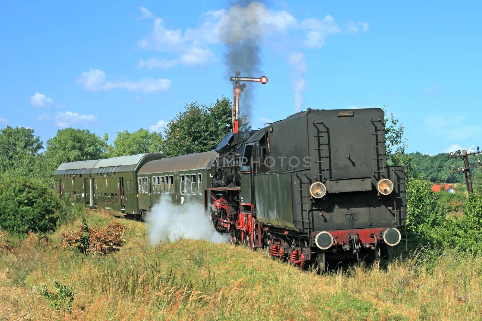 Old retro steam train passing through polish countryside
