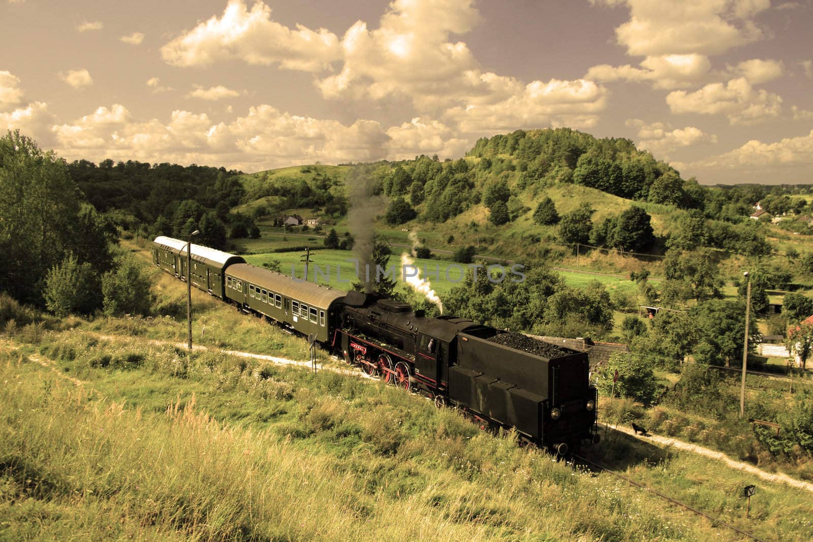 Beautiful hilly landscape with an old retro steam train
