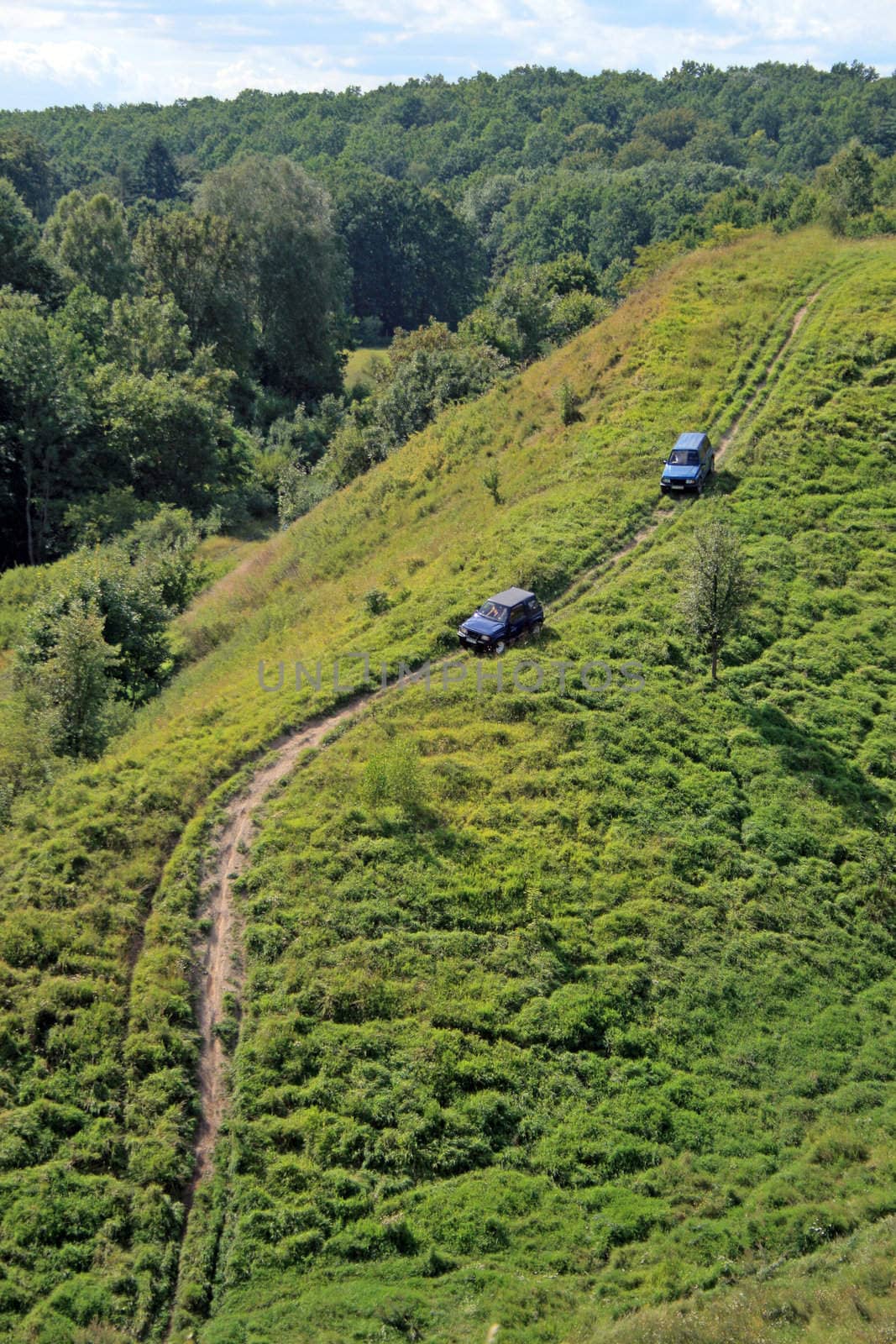 Off-road. Two 4x4 jeeps tries to climb up top of a hill
