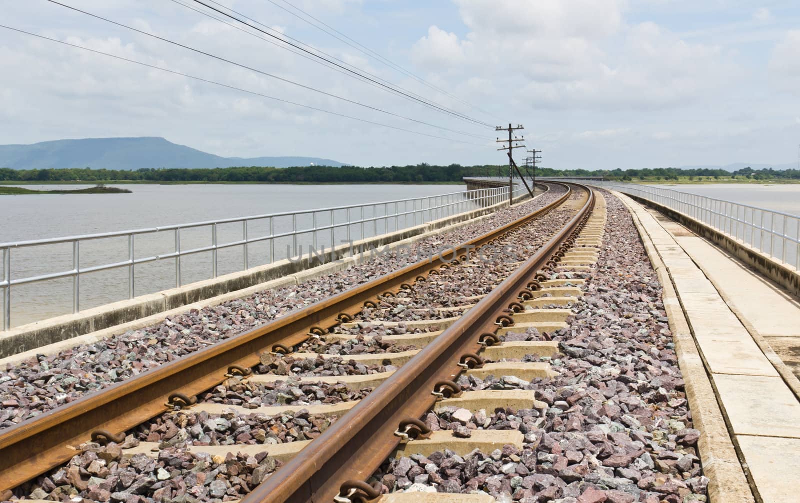 Railroad tracks curving  across the lake