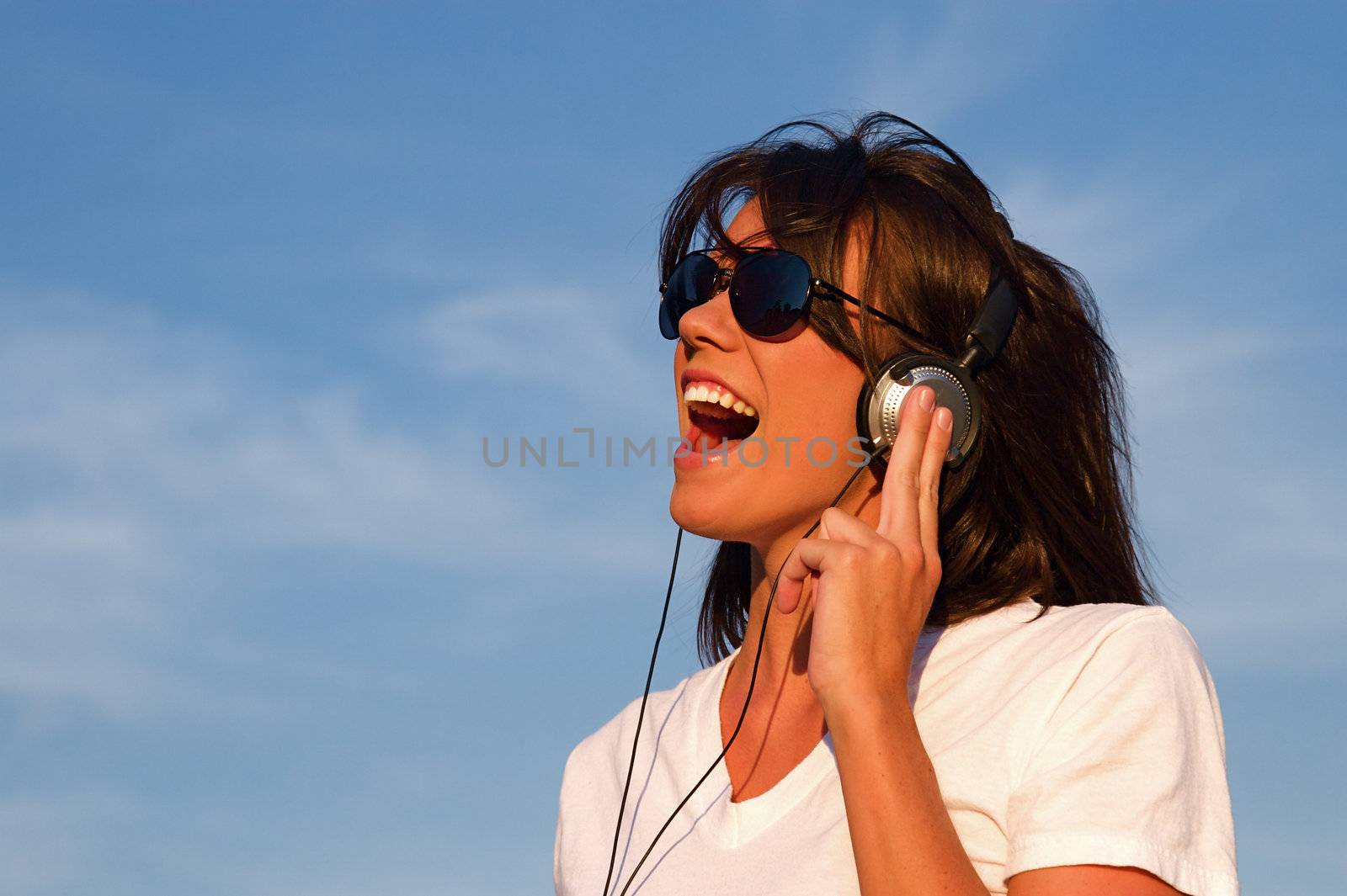 A cool young woman listens to music on some headphones