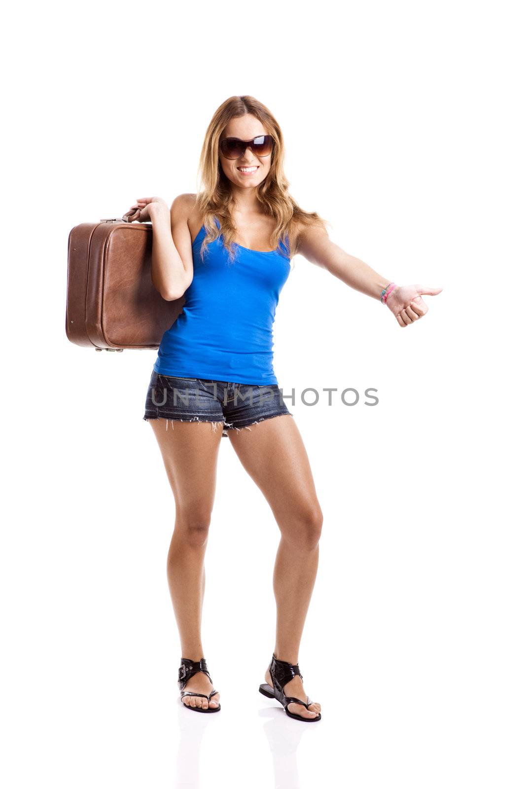 Beautiful young woman hitch hiking with old leather suitcase, isolated on white