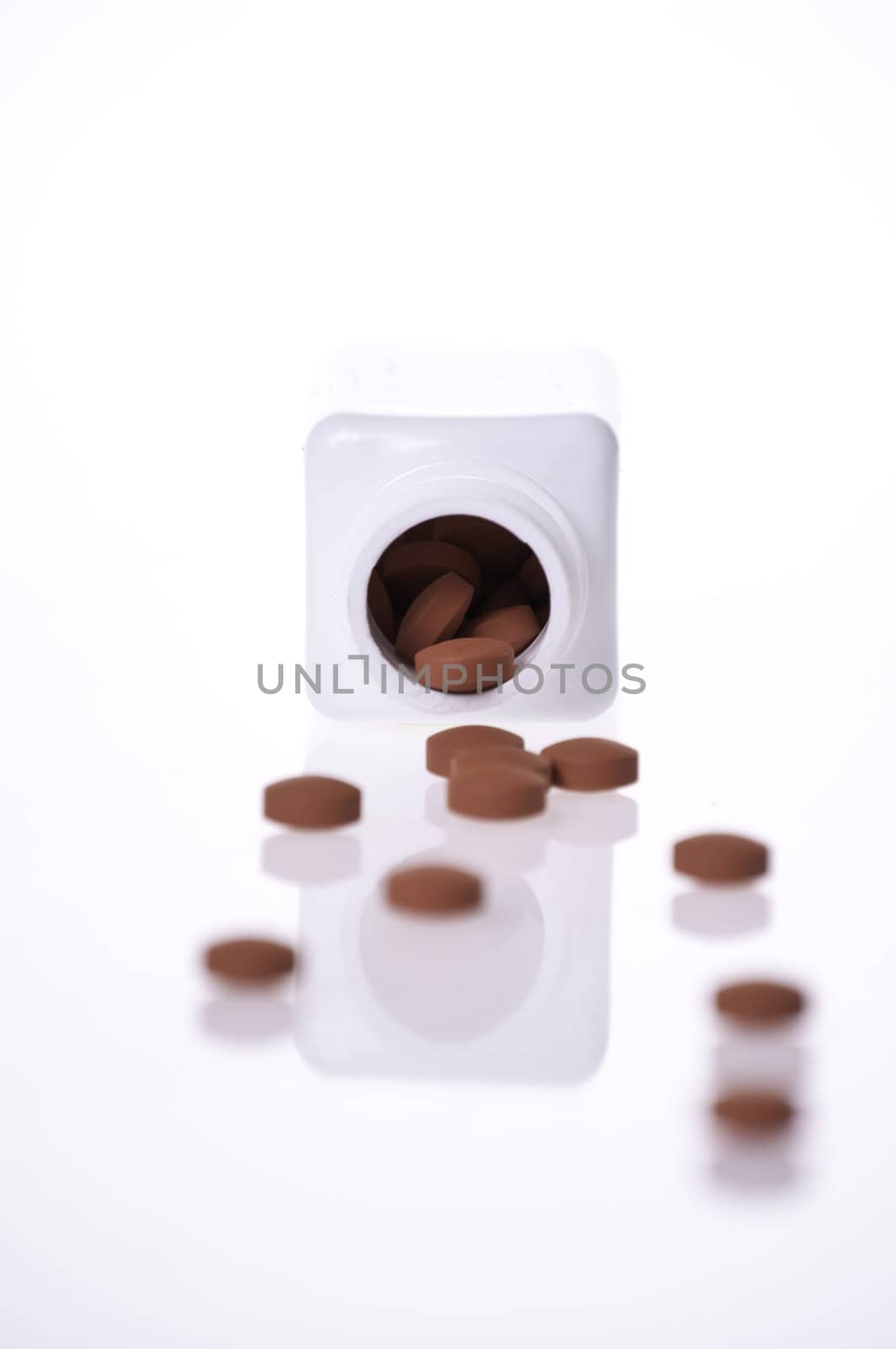 A white pill bottle with red generic pills  on a white background.