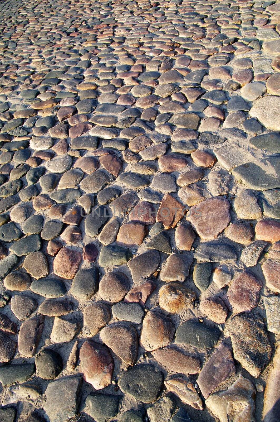 Cobblestone pavement texture, background shot in warm evening sunlight