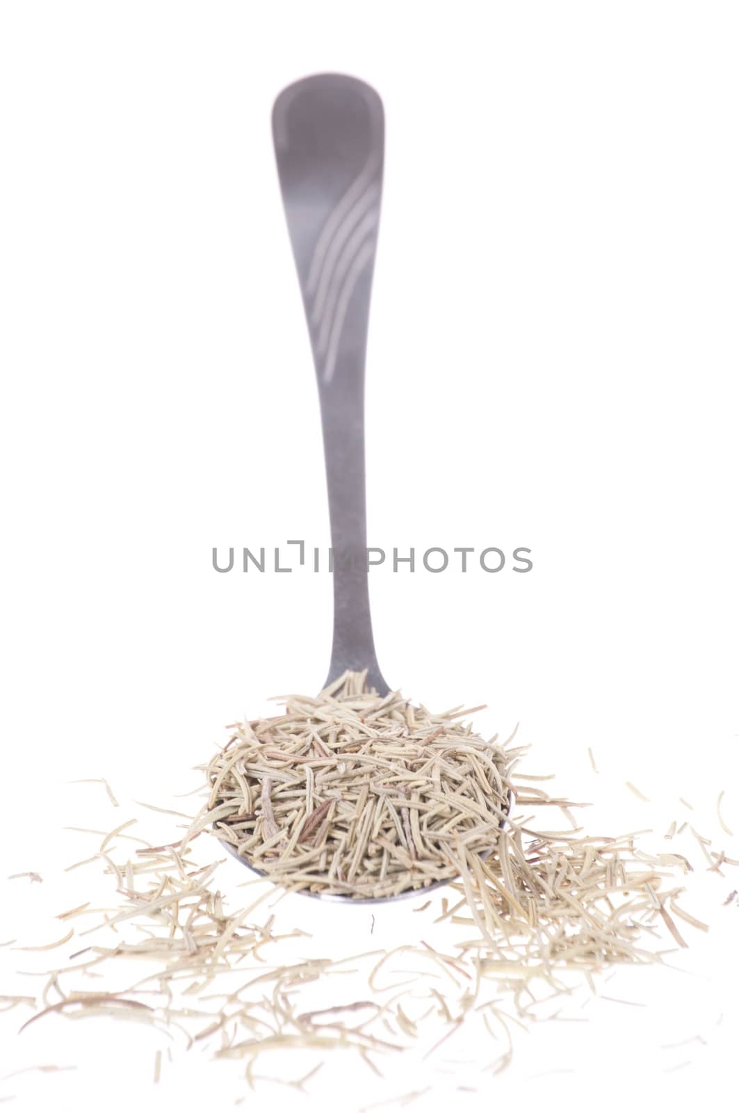 Tablespoon full of dry rosemary leaves isolated on white