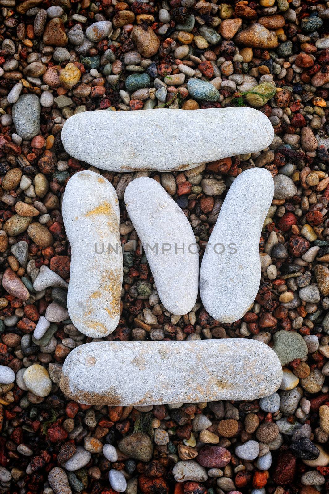 Number "4" form of pebbles, isolated on the background of sea gravel