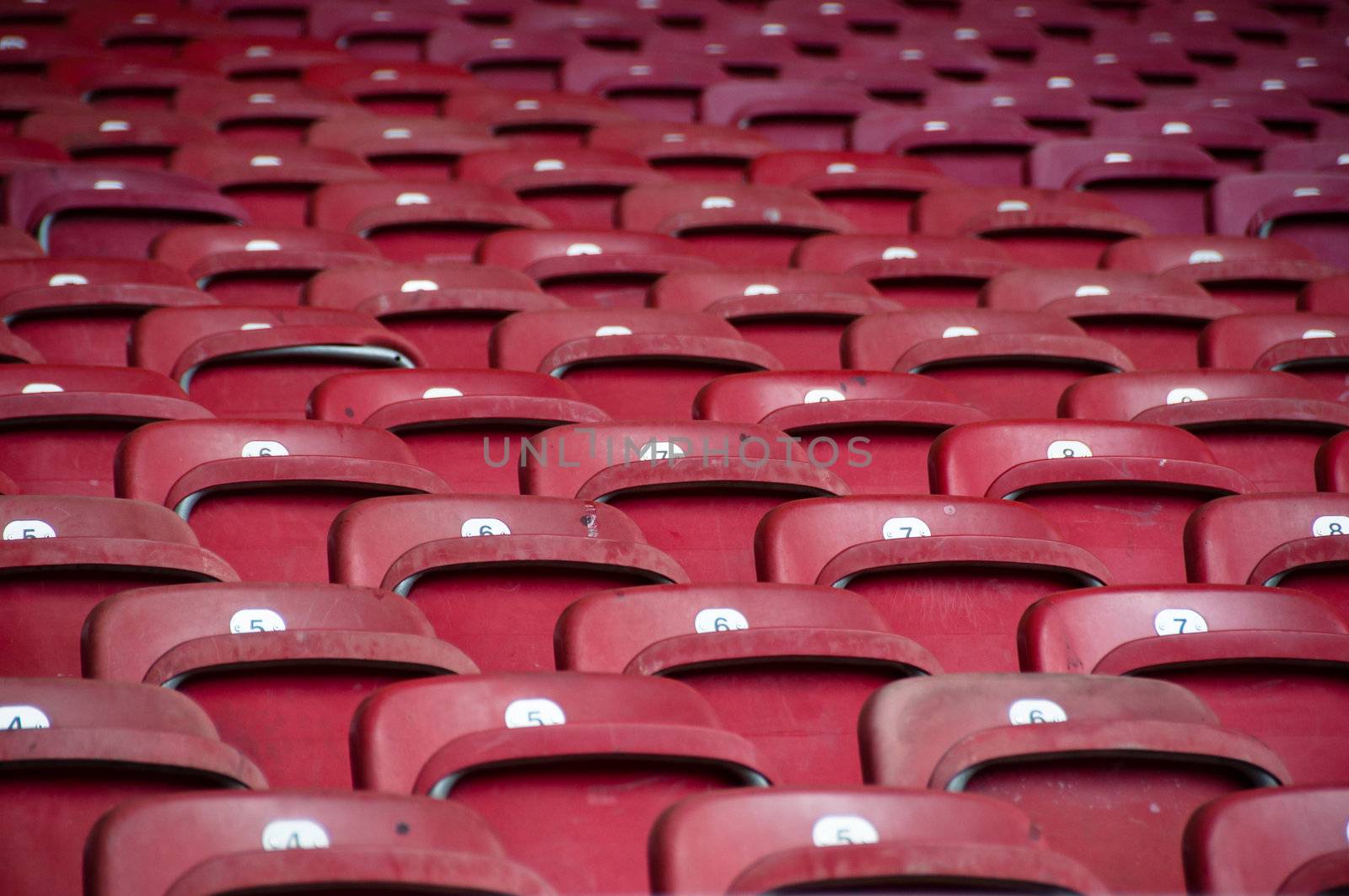 Rows of empty red seats in a football stadium
