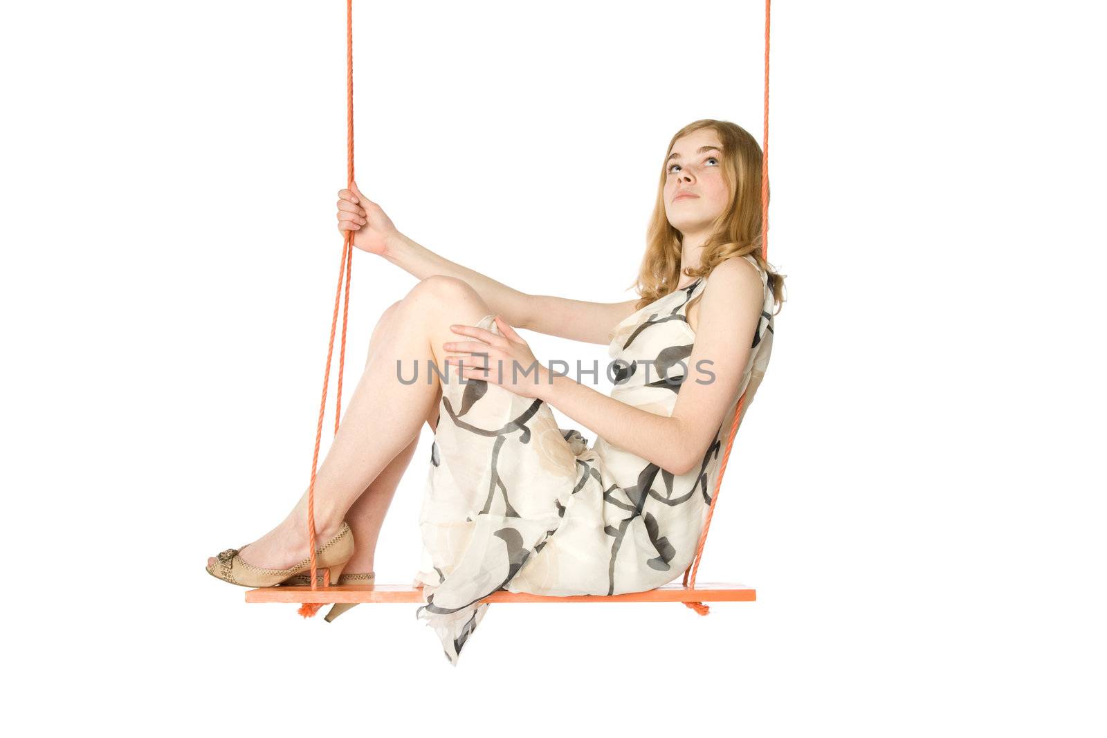 Young blond sitting on a swing, white background