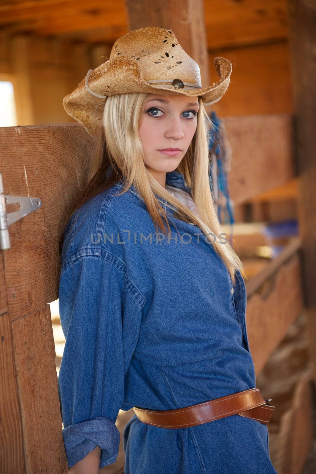 Beautiful Blonde Girl Wearing Cowboy Hat in Barn by pixelsnap