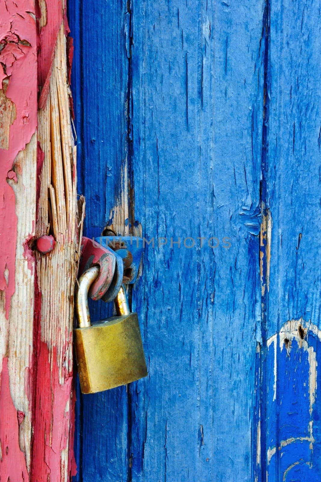 Padlock locking a highly textured wooden door
