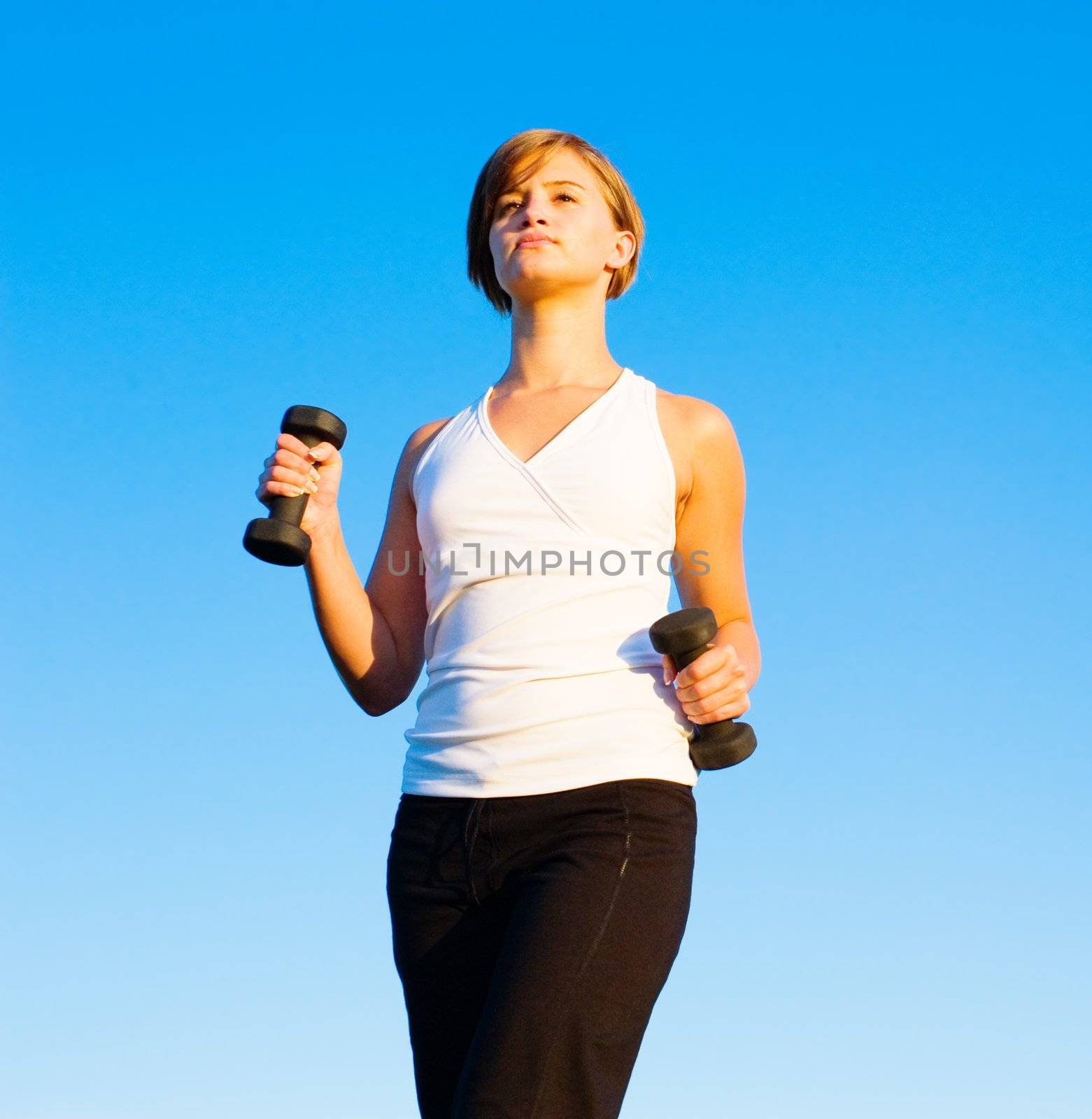 Young woman walking with weights, from a complete series of photos.