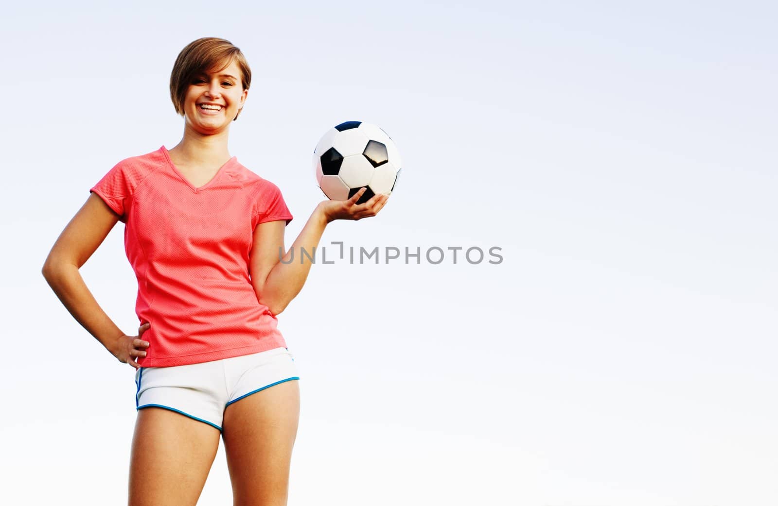 Young woman playing soccer in a field, from a complete series of photos.