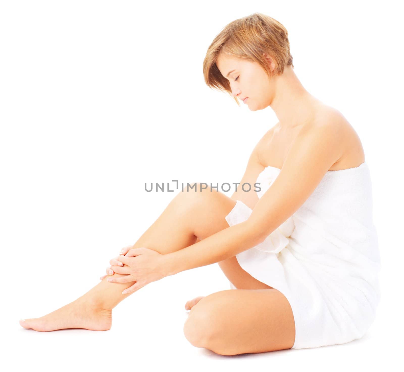 Woman in towel massaging herself isolated on white, from a complete series of photos.