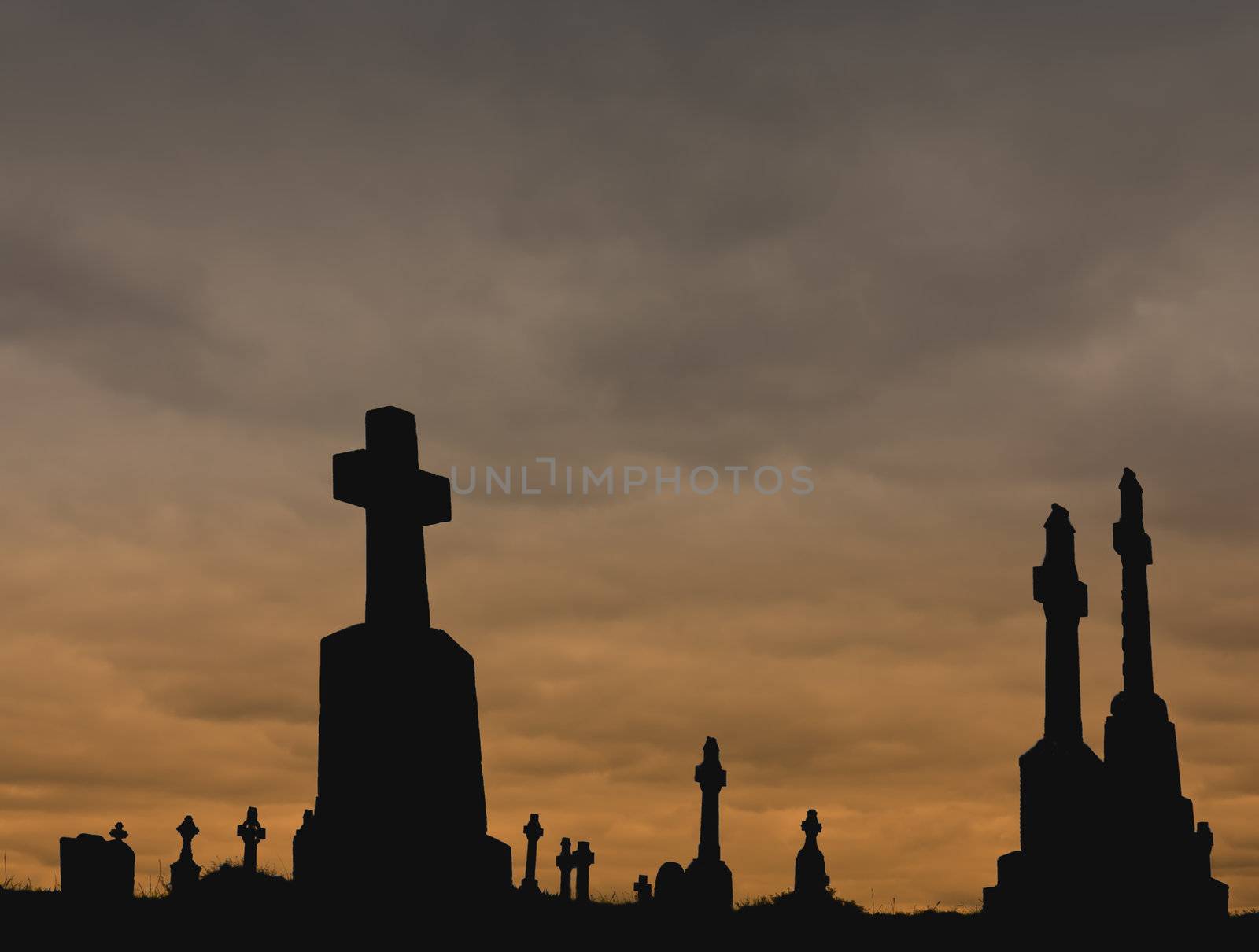 Silhouettes of Christian and Celtic crosses against a colored cloudy sky. Perfect for Halloween!