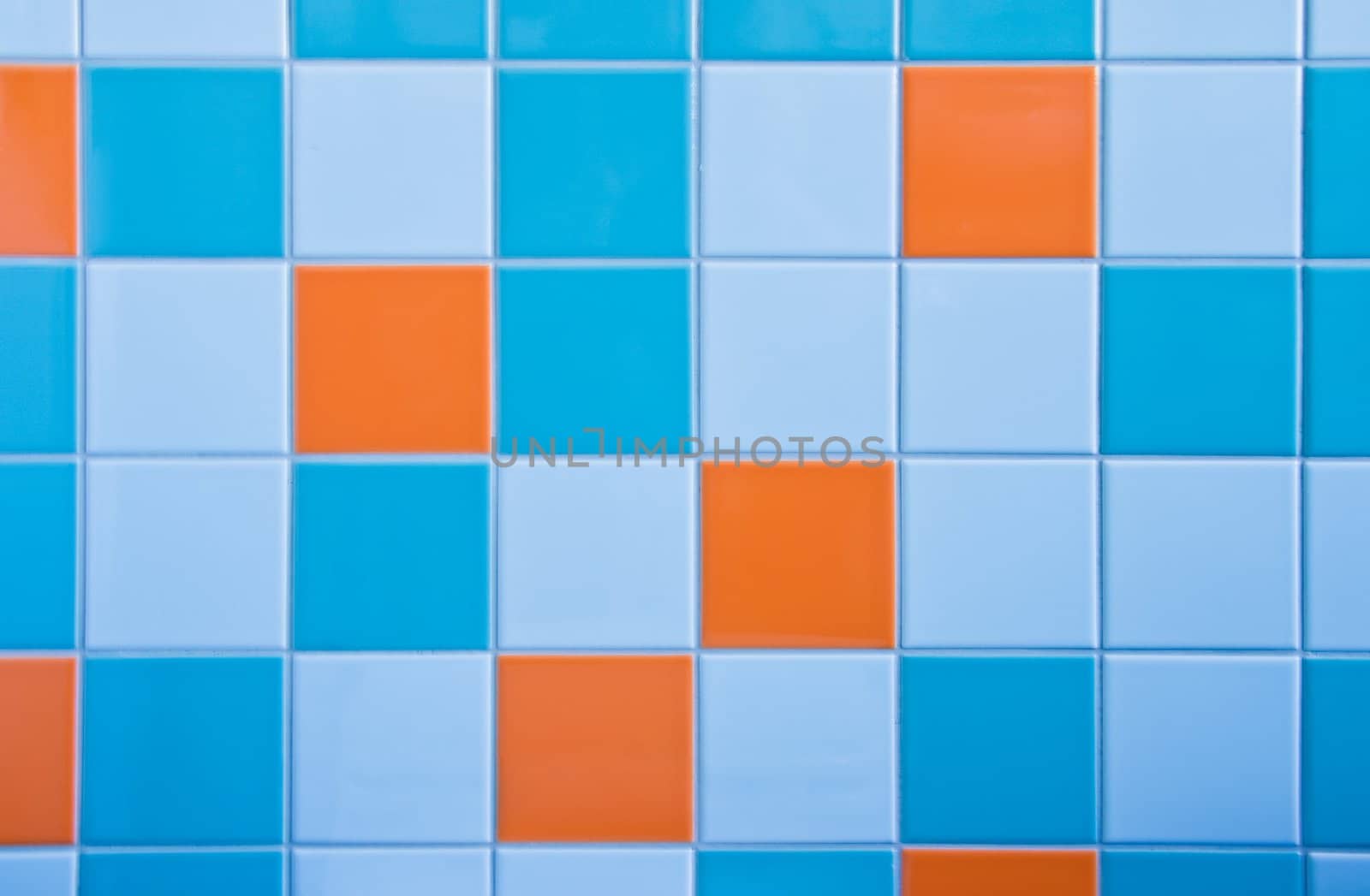 Part of wall in bathroom with tiles in light blue, azure blue and orange