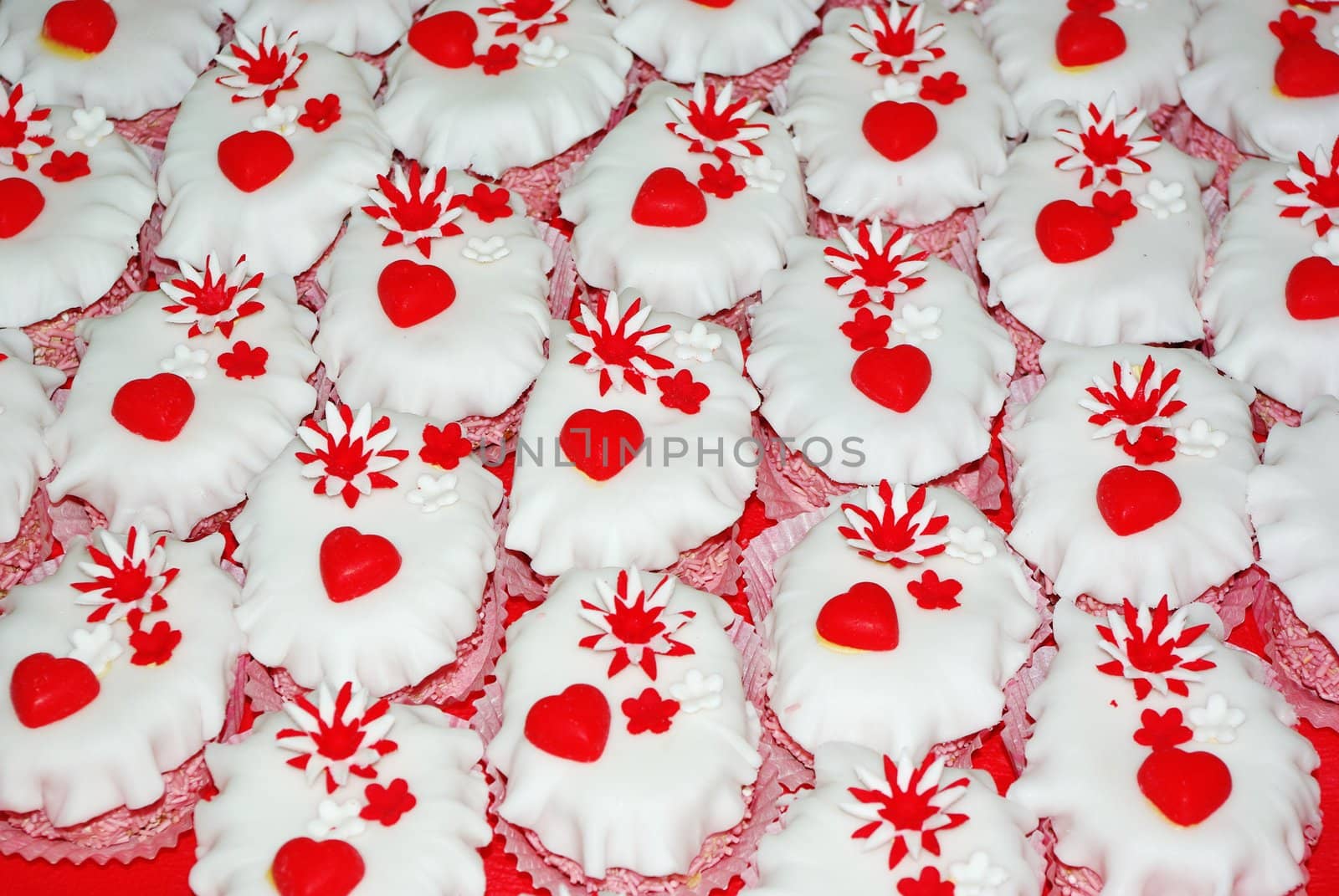 A lot of cakes decorated with little red hearts
