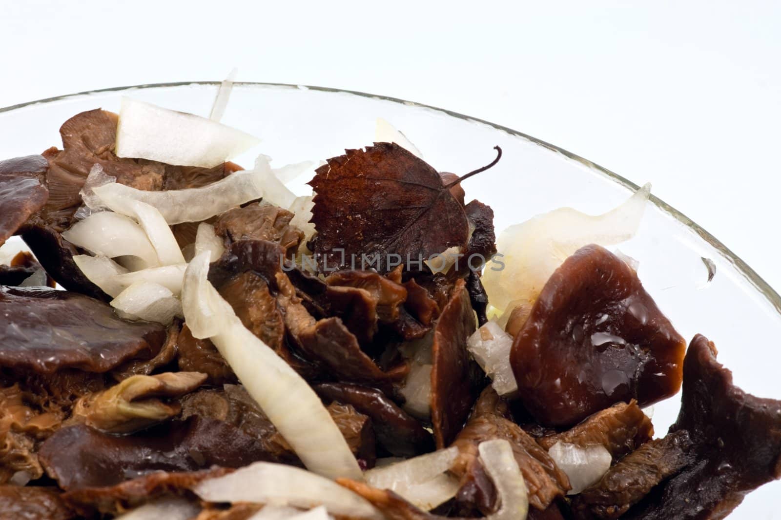 Salted mushrooms with sliced onion and olive oil in glass bowl 