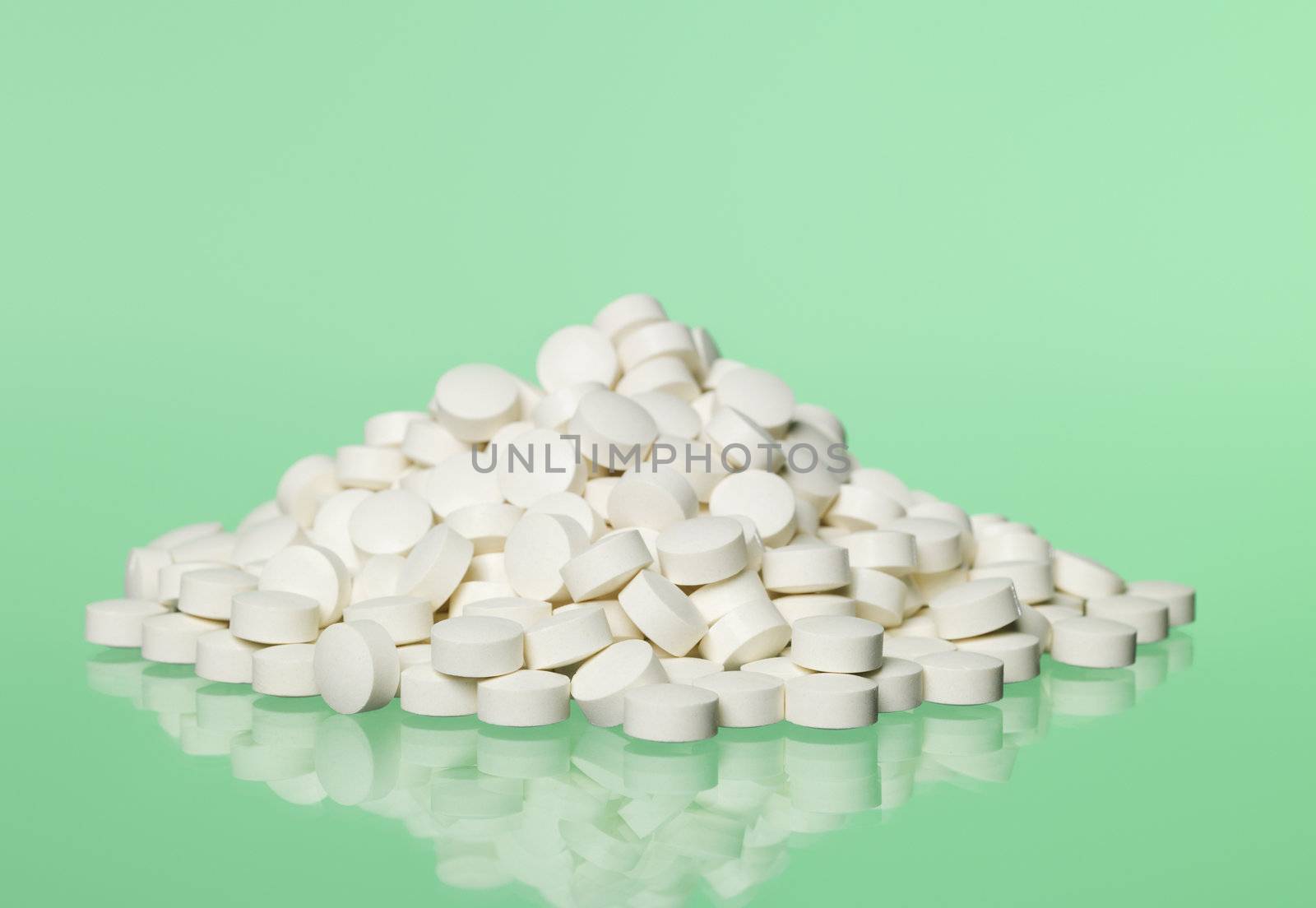 Stack of pills towards green background