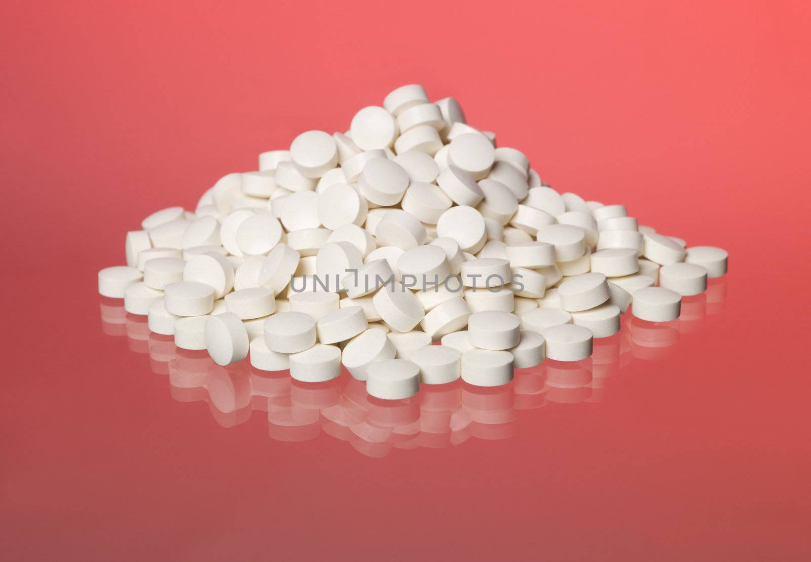 Stack of pills towards red background by gemenacom