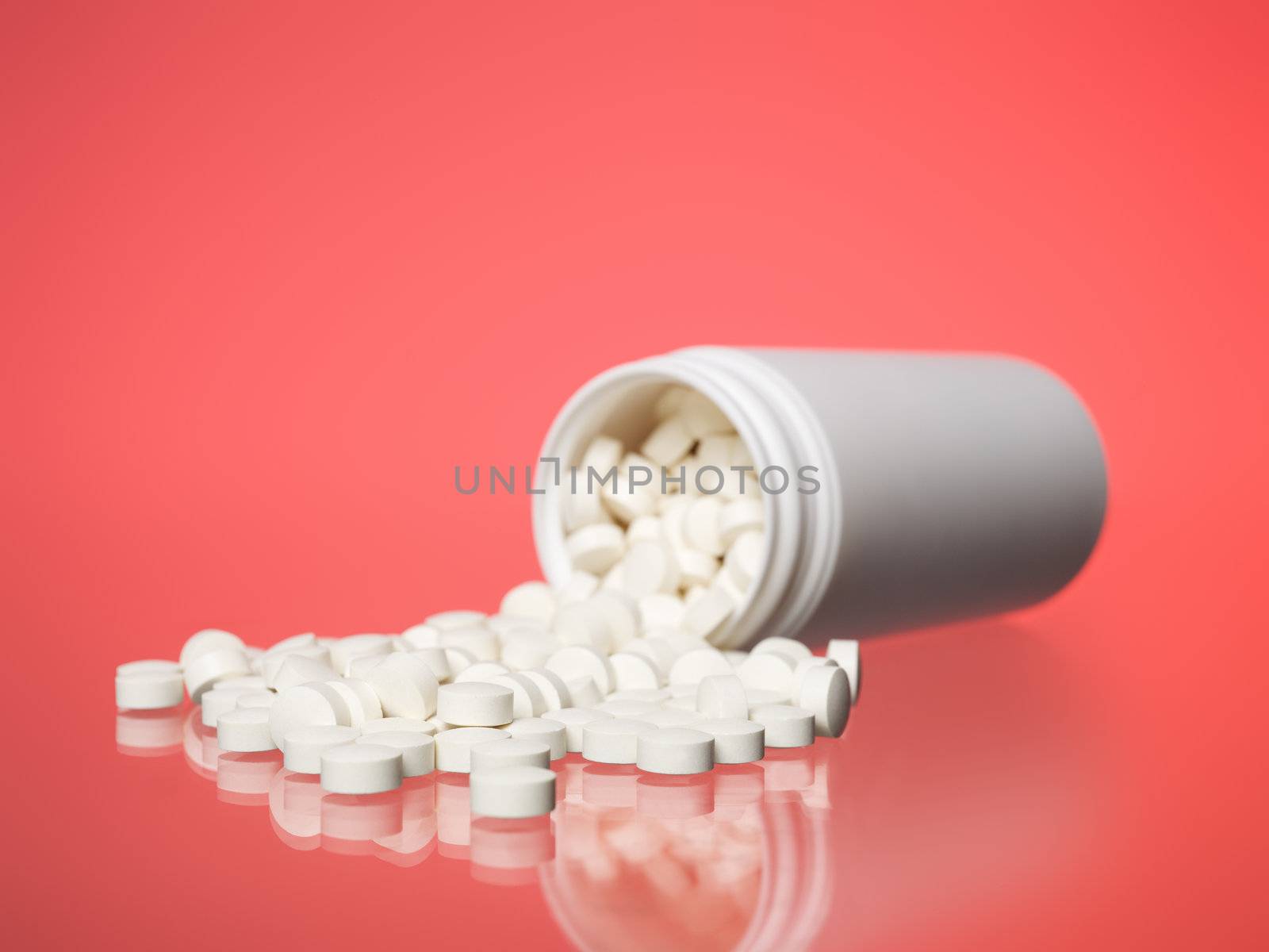 Can with pills towards red background