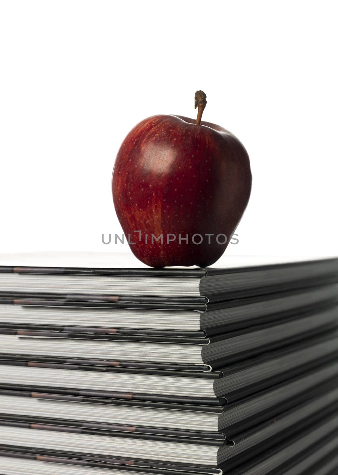 pile of books with a apple