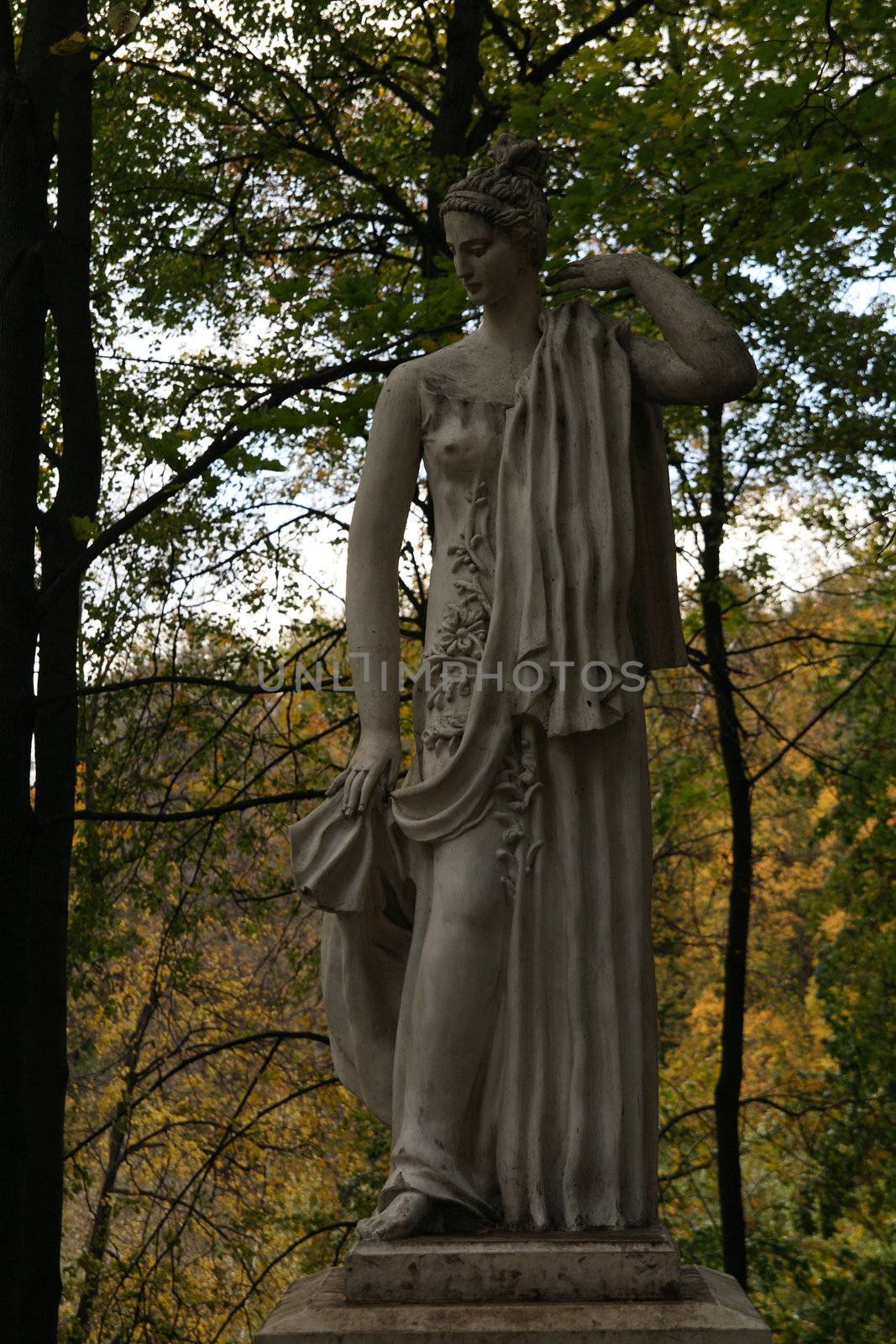 Ancient female statue in autumn park in full-length