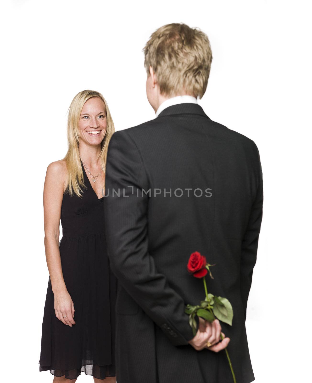 Man with a rose behind his back and a happy woman