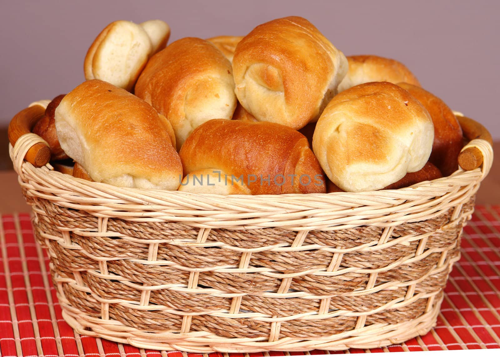 A basket with fresh baked bun and croissants.                               